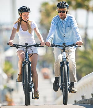 Young couple riding electric bikes together